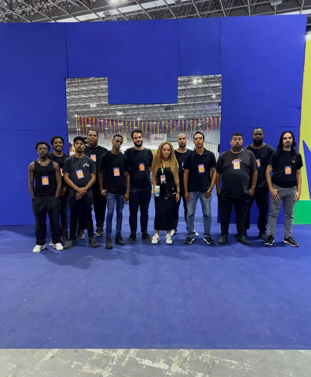 Profissionais da Agência Portes reunidos em um pavilhão de eventos